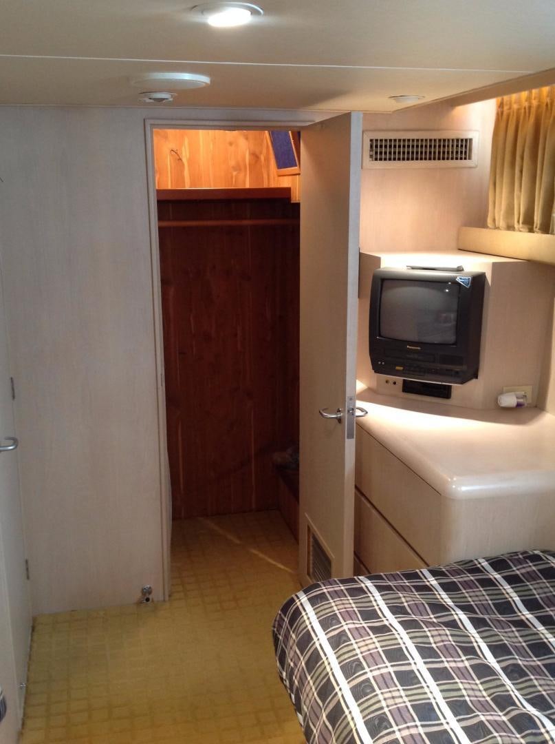 a bedroom with a tv and a bed aboard AUDACITY Yacht for Sale
