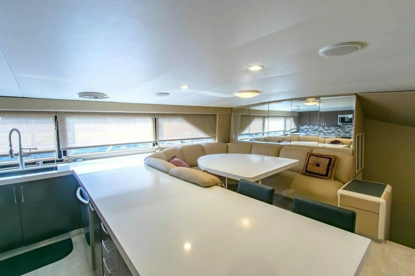 a large modern looking room with a large white table and chairs aboard AUDACITY Yacht for Sale