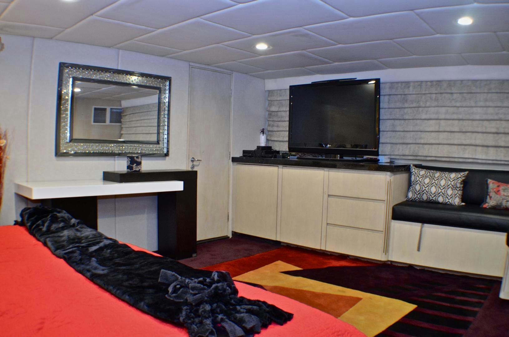 a bedroom with a bed and a tv aboard AUDACITY Yacht for Sale