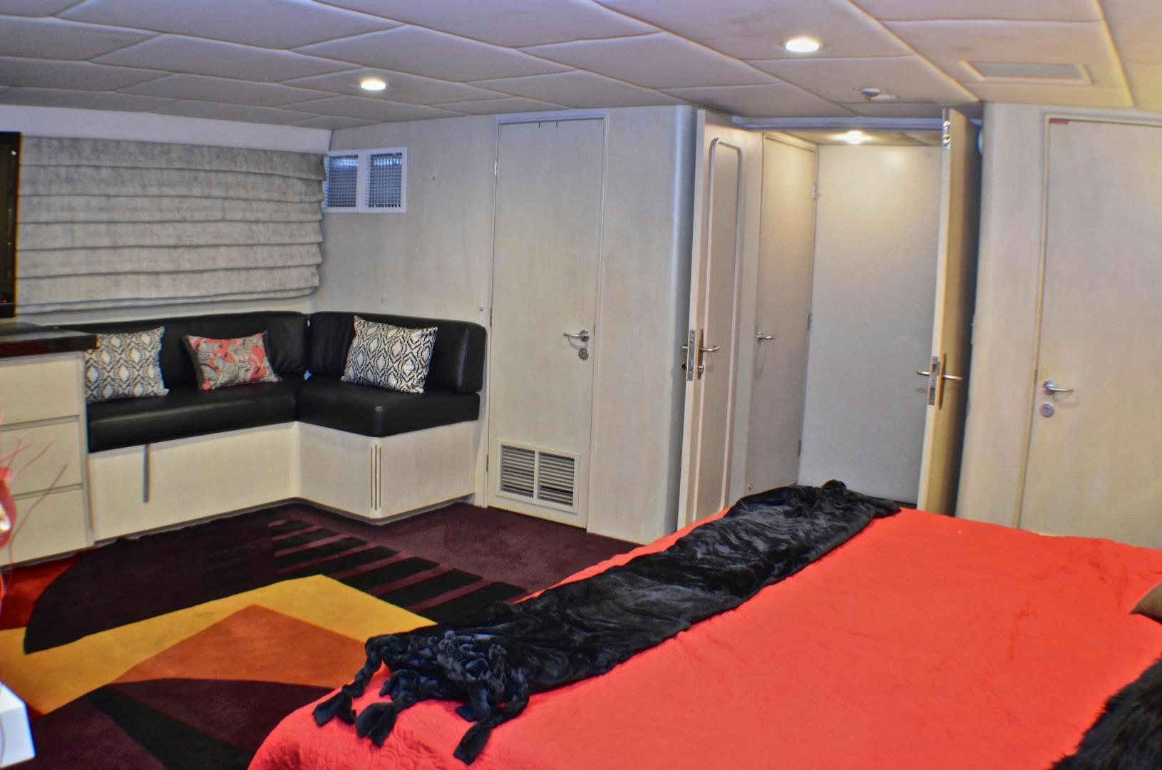 a bedroom with a bed and a couch aboard AUDACITY Yacht for Sale