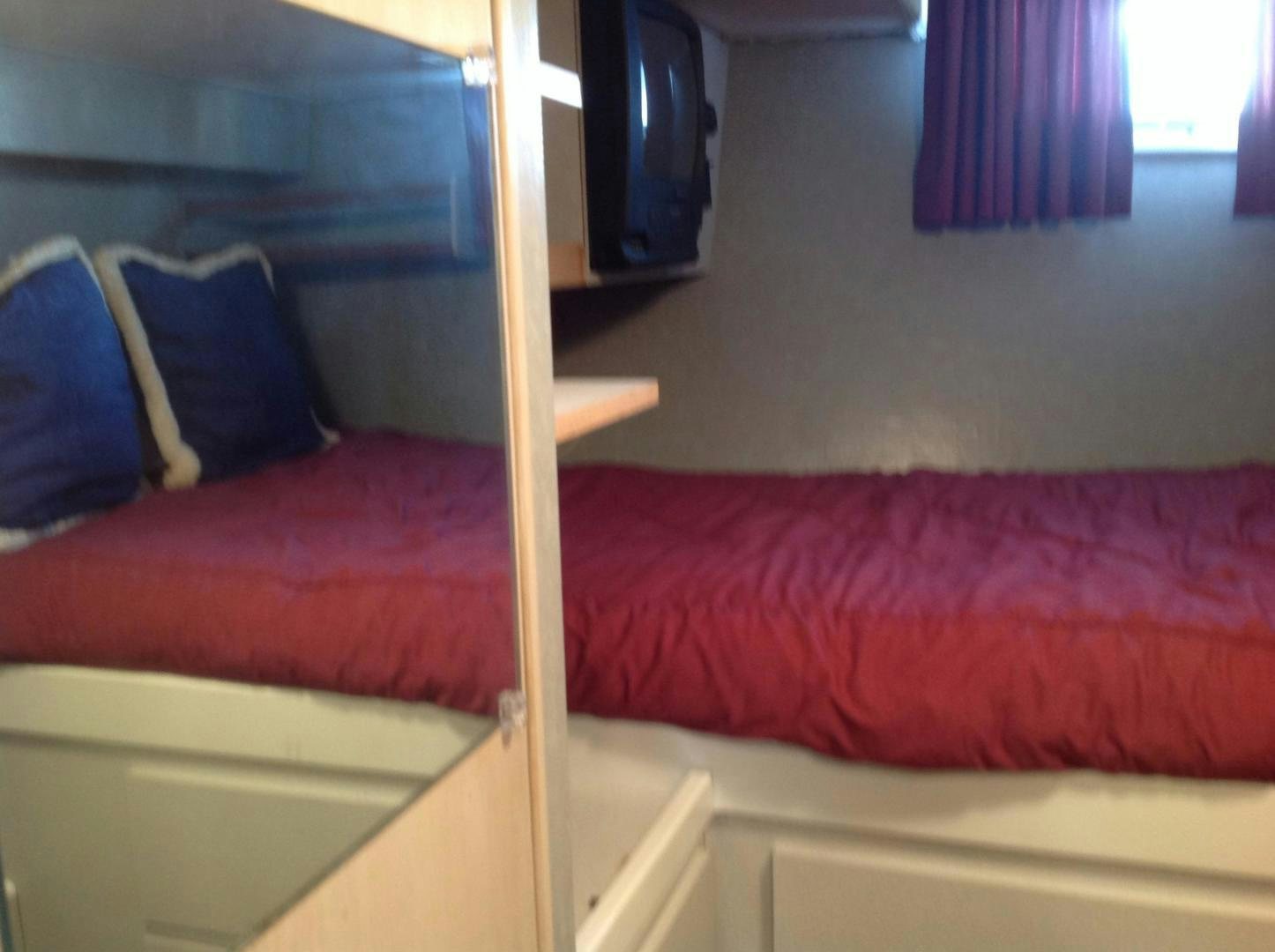 a red pillow on a bed aboard AUDACITY Yacht for Sale
