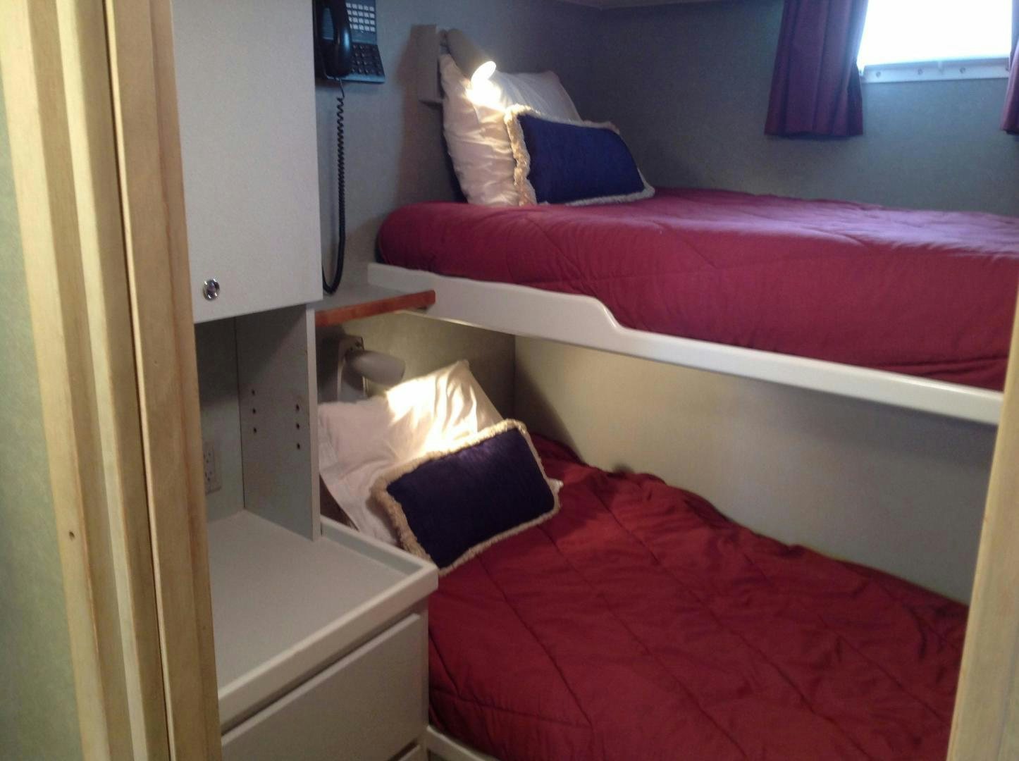 a bed with red sheets aboard AUDACITY Yacht for Sale