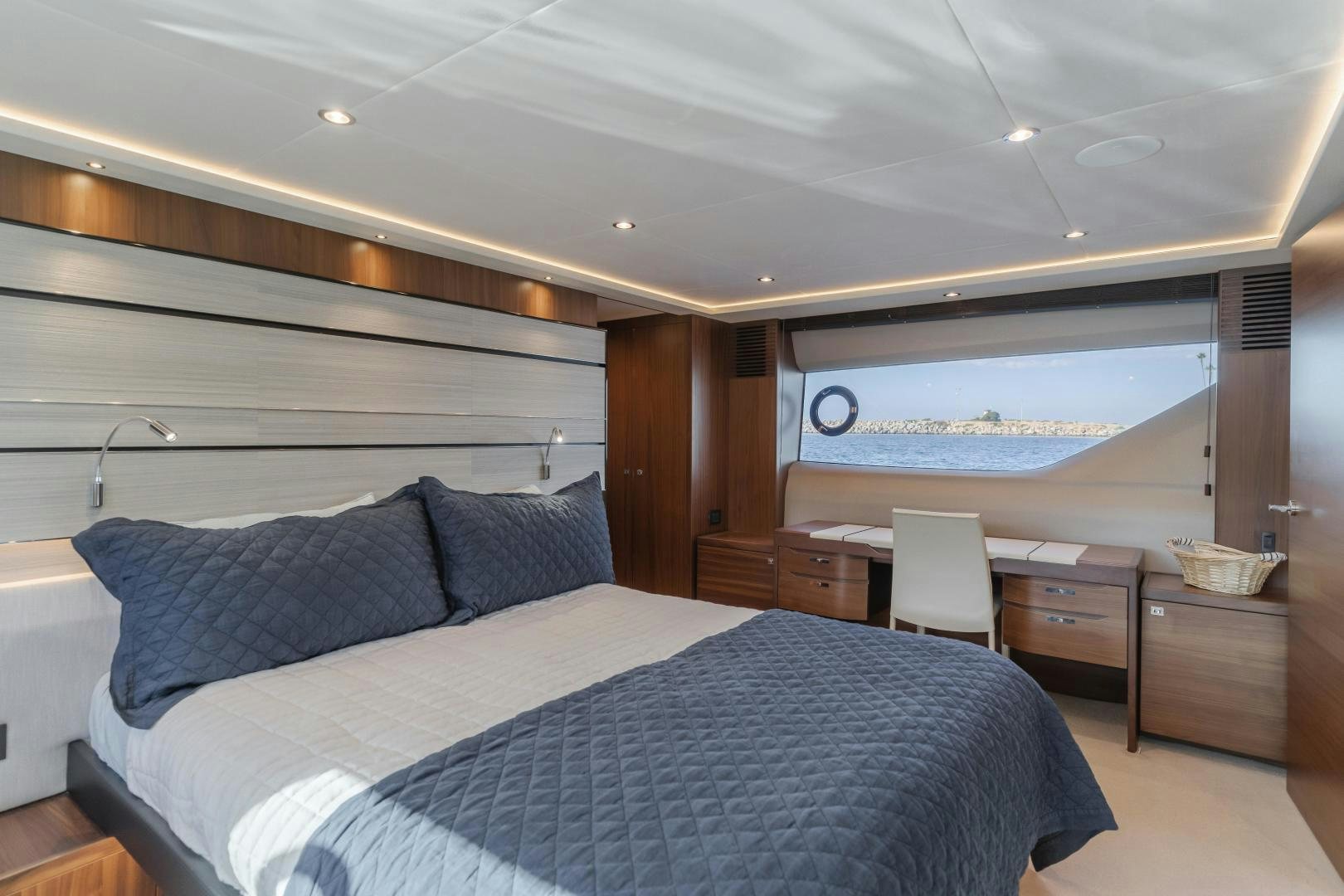 a bedroom with a bed and a chair aboard SEXSEA Yacht for Sale