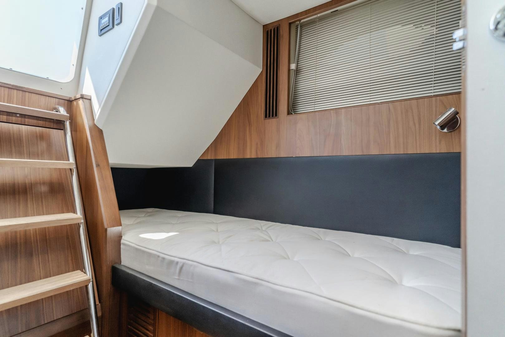 a bed with a wooden headboard aboard SEXSEA Yacht for Sale