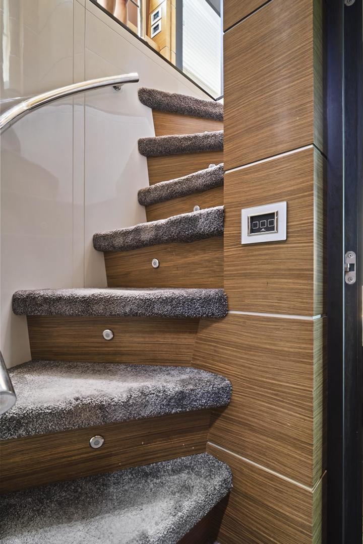 a wooden staircase with a light fixture aboard EL PATRON Yacht for Sale