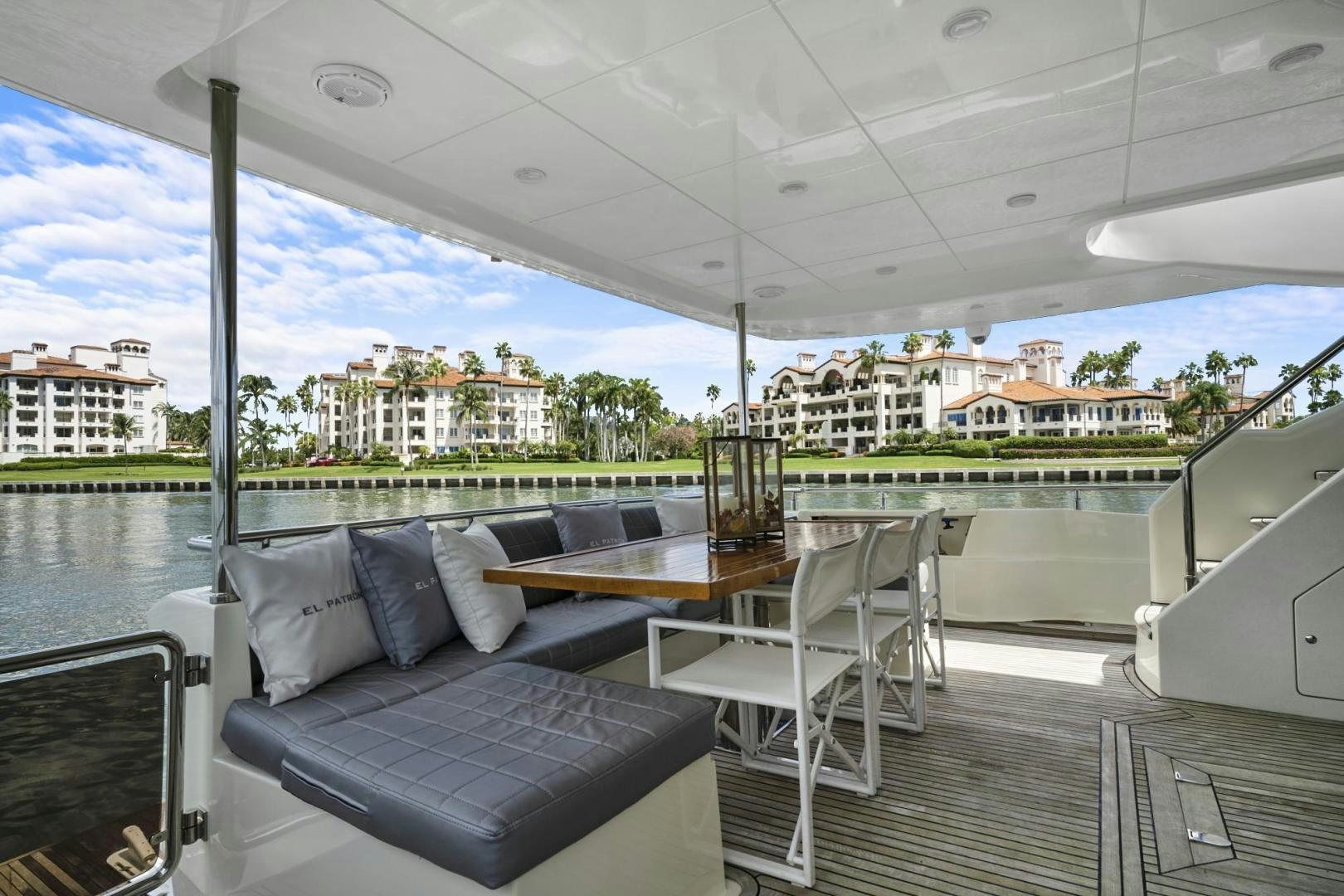 a deck with a couch and a table on it aboard EL PATRON Yacht for Sale