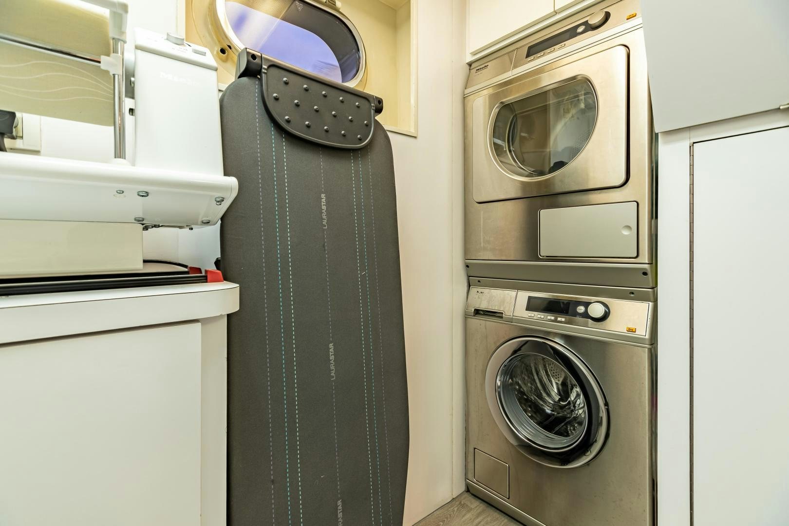 a room with a washing machine and dryer aboard EXPLORA Yacht for Sale