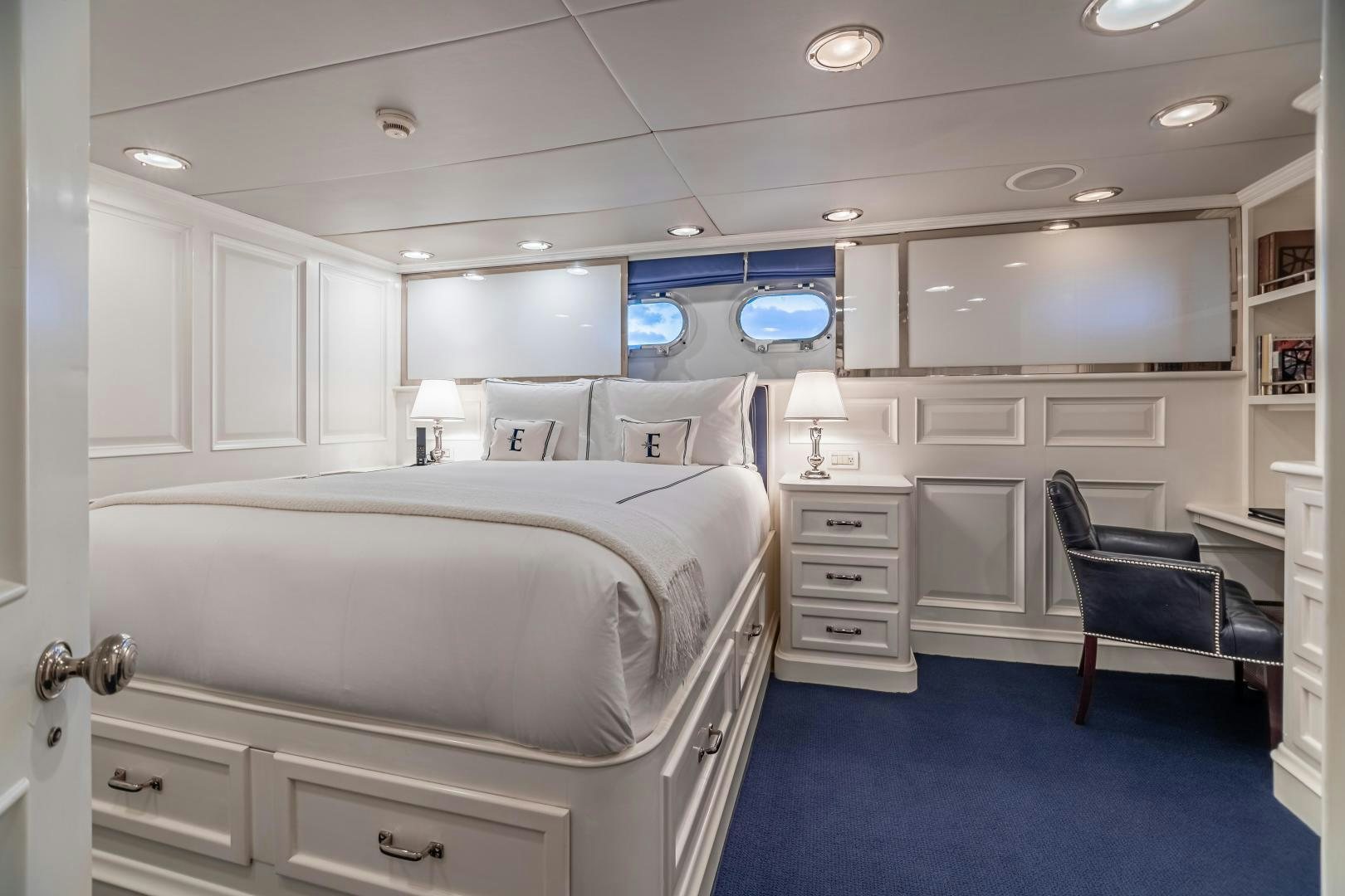 a room with a bed and a chair aboard EXPLORA Yacht for Sale