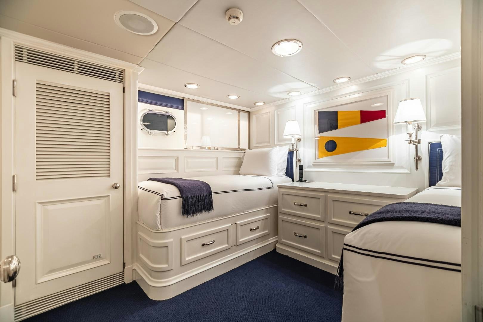 a bedroom with a bed and a desk aboard EXPLORA Yacht for Sale