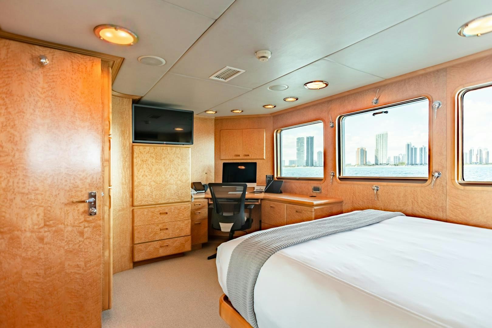 a bedroom with a bed and a desk aboard EXPLORA Yacht for Sale