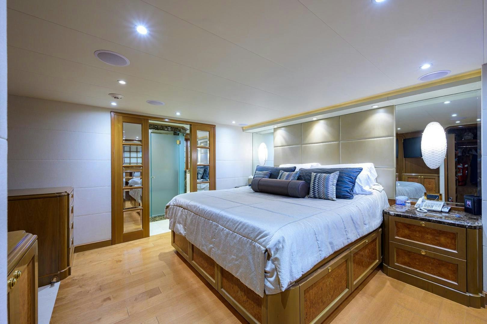a bedroom with a bed and a mirror aboard THE CROWN ROYAL Yacht for Sale