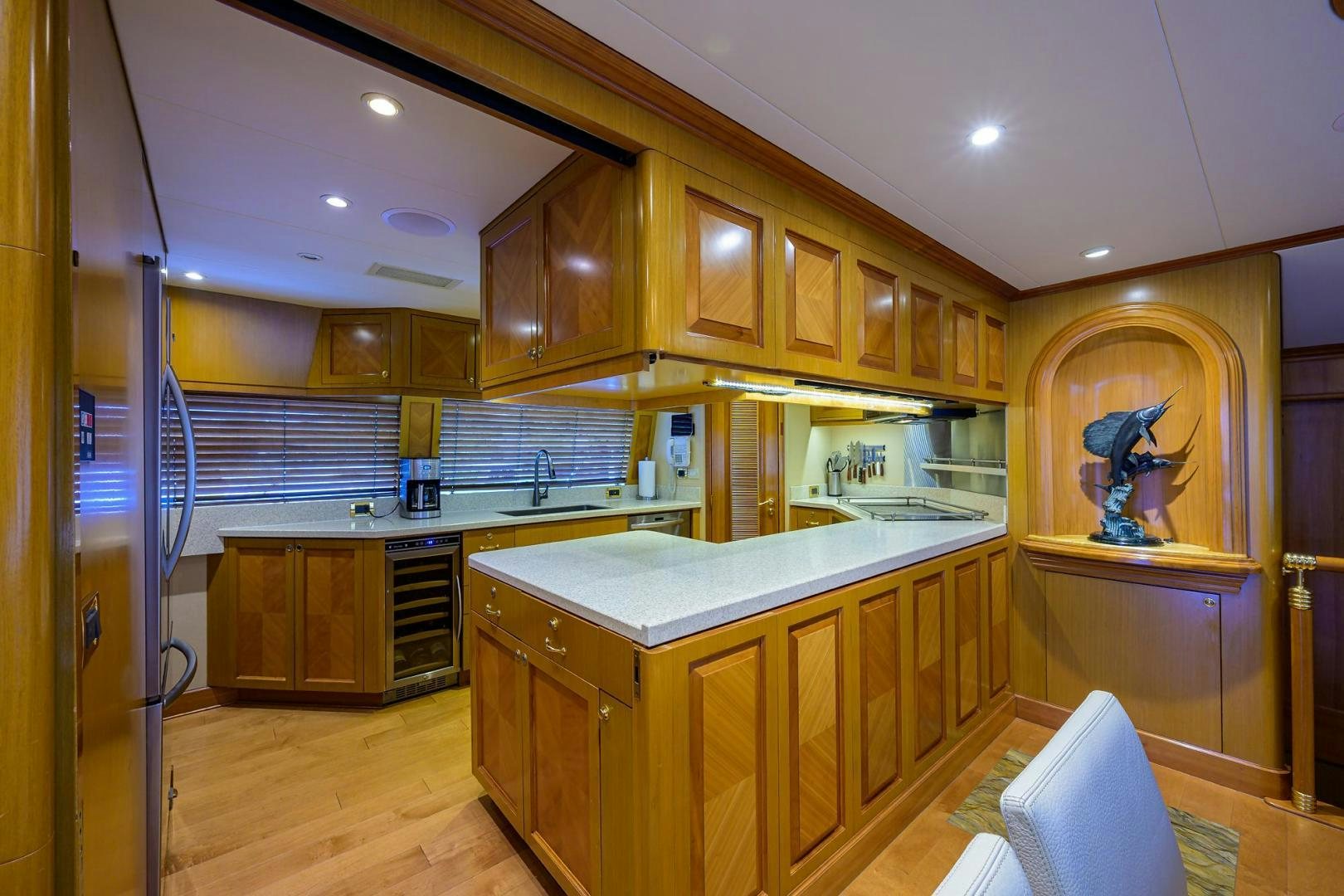 a kitchen with wooden cabinets aboard THE CROWN ROYAL Yacht for Sale