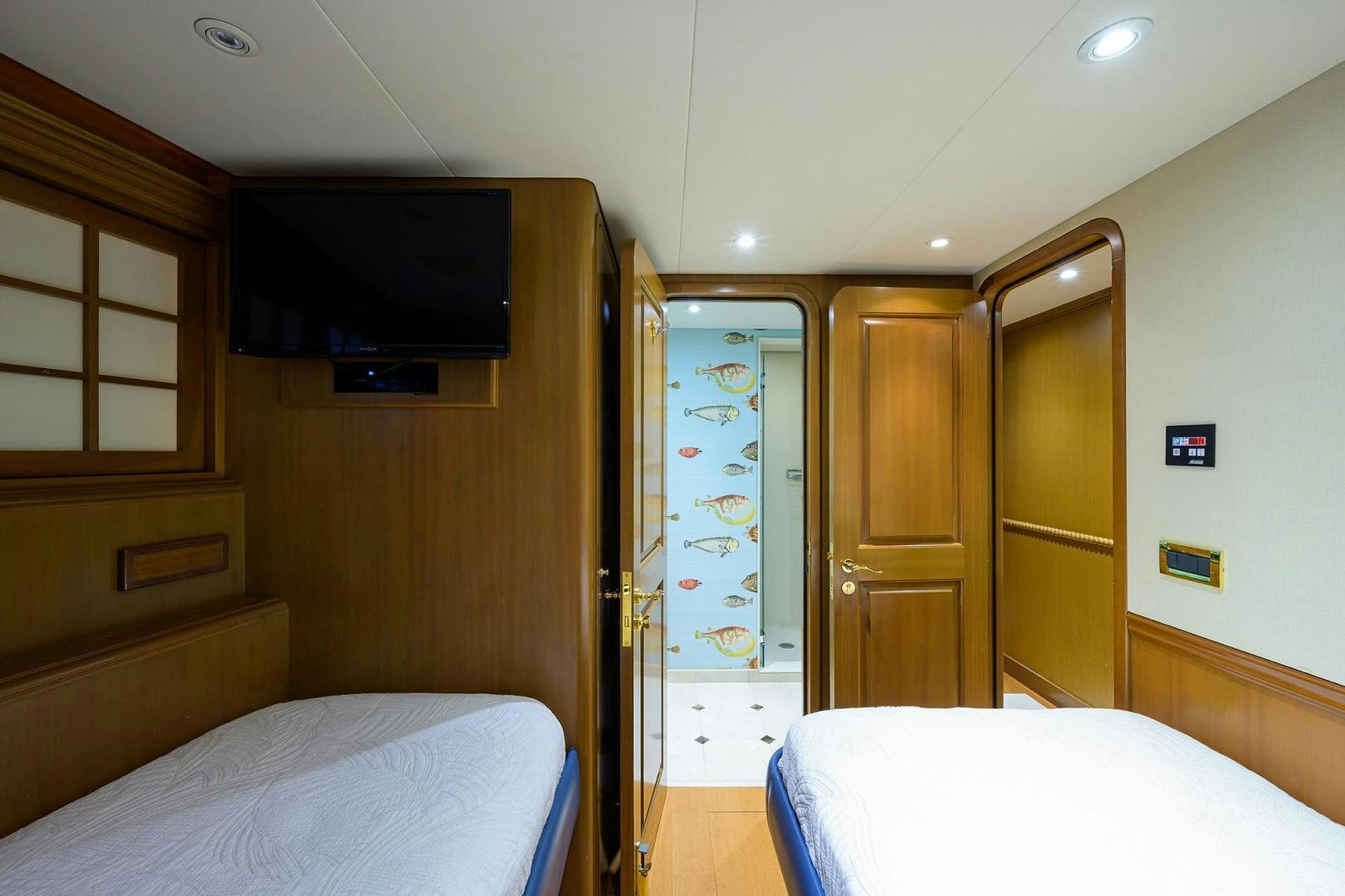 a bedroom with a bed and a television aboard THE CROWN ROYAL Yacht for Sale