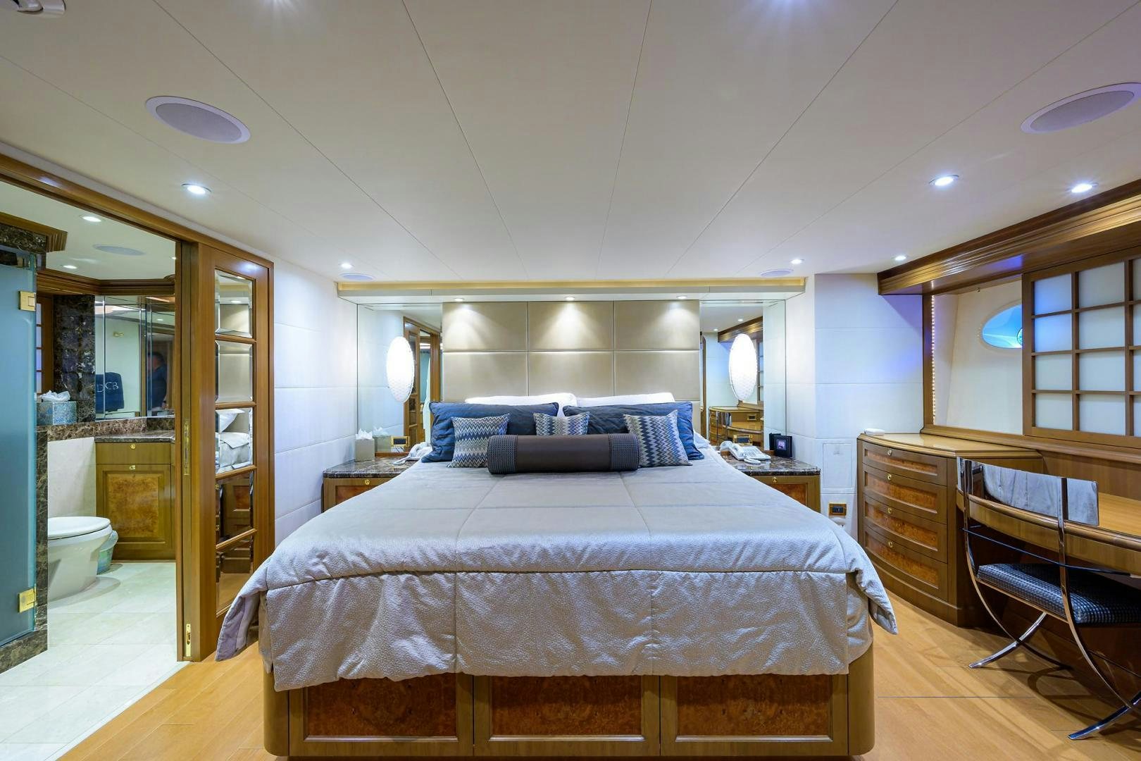 a bedroom with a bed and a mirror aboard THE CROWN ROYAL Yacht for Sale
