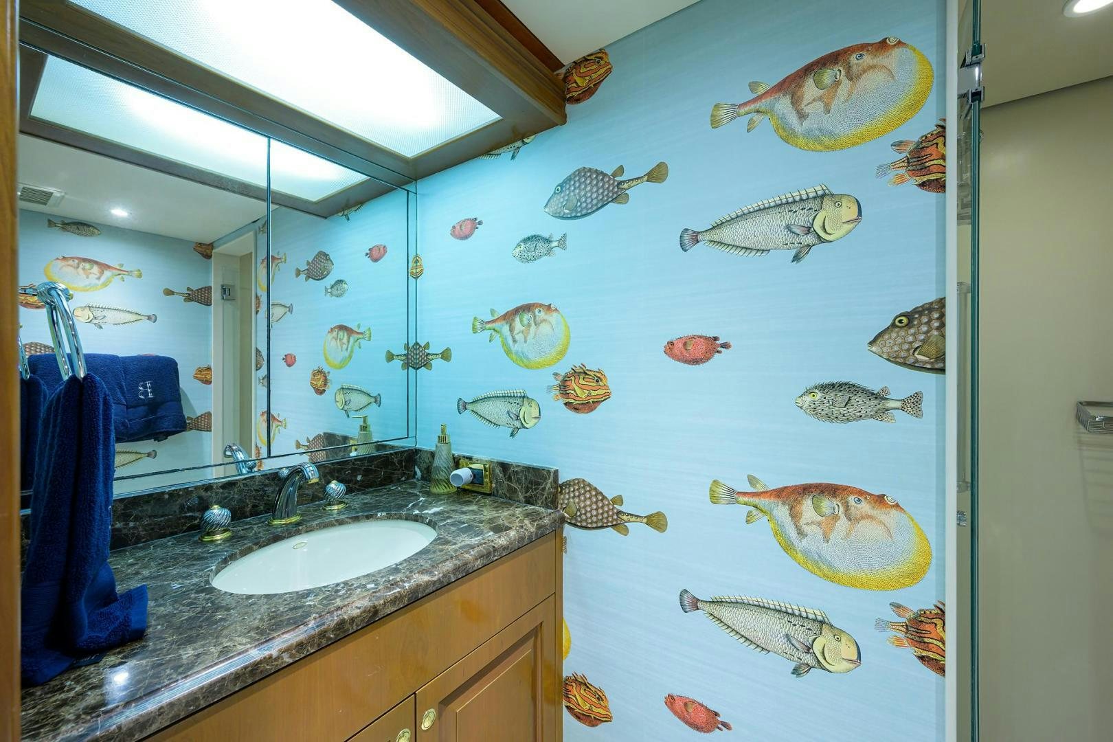 a bathroom with a sink and fish mural on the wall aboard THE CROWN ROYAL Yacht for Sale