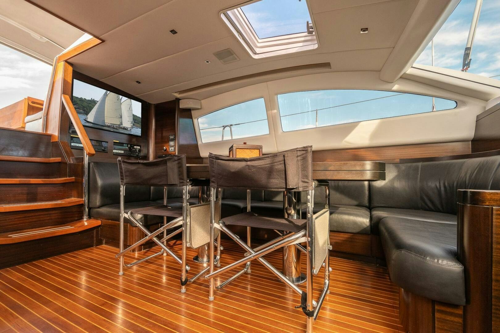 a room with leather chairs and a wood floor aboard KAHUNA Yacht for Sale