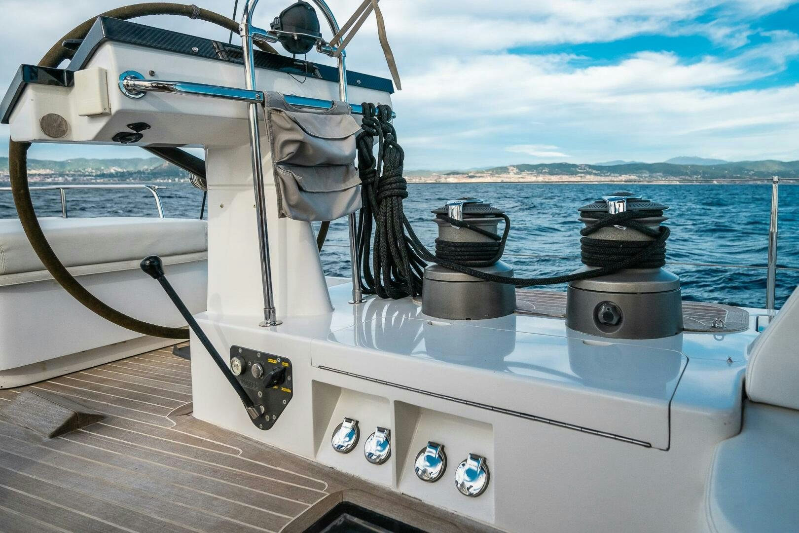a boat with a steering wheel and a ship in the background aboard KAHUNA Yacht for Sale