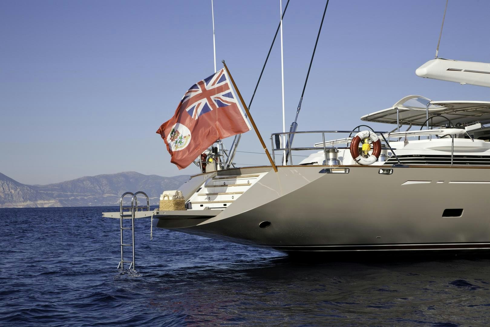 a boat with a flag on it aboard DESTINATION Yacht for Sale