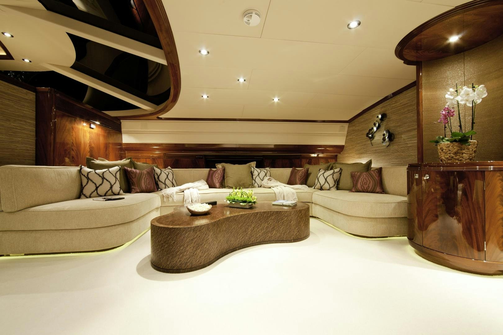 a living room with a large white couch and a large mirror aboard DESTINATION Yacht for Sale