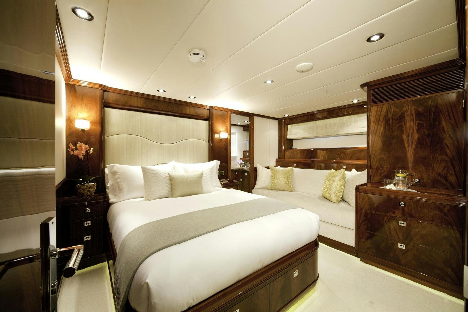 a bedroom with a bed and a dresser aboard DESTINATION Yacht for Sale