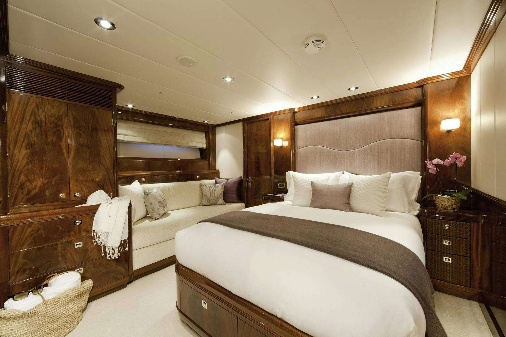 a bedroom with a bed and a dresser aboard DESTINATION Yacht for Sale