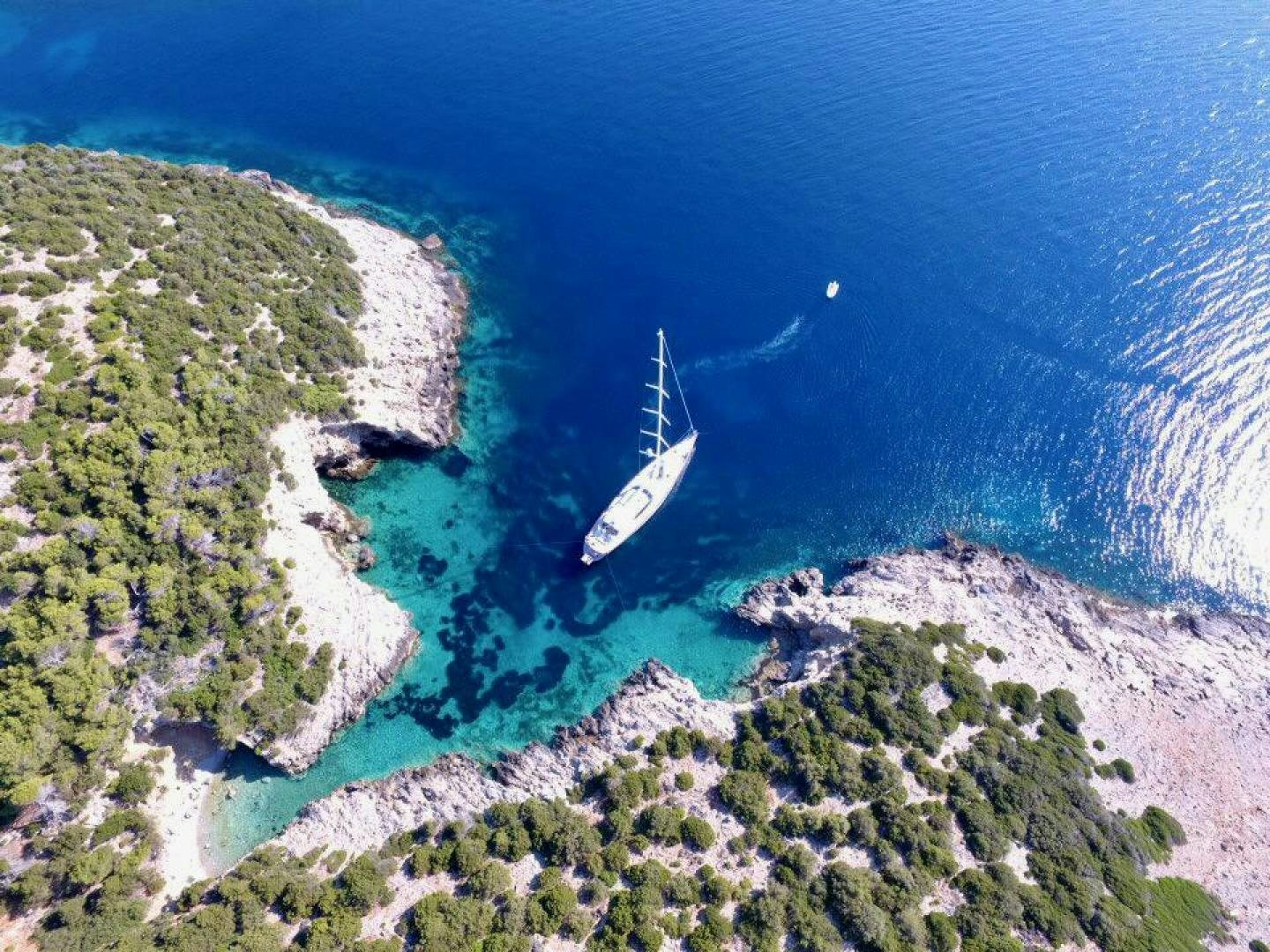 a beach with a beach and a boat in the water aboard DESTINATION Yacht for Sale