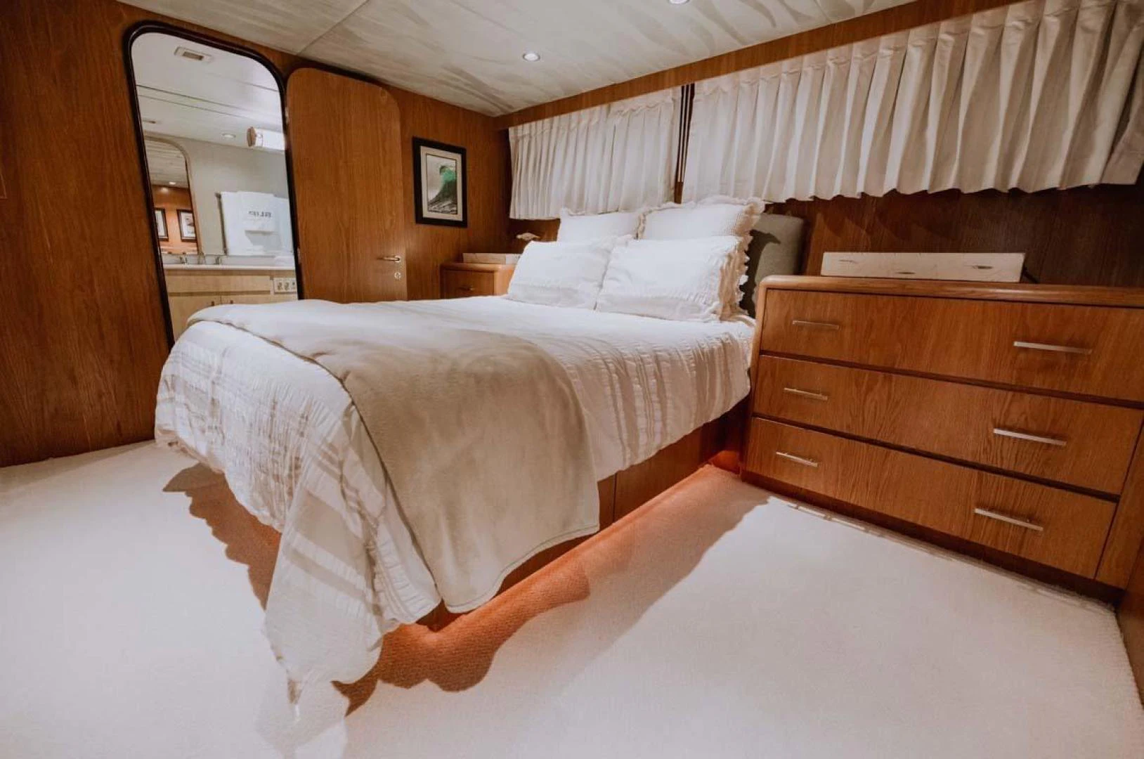 a room with a bed and a dresser aboard SUP Yacht for Sale