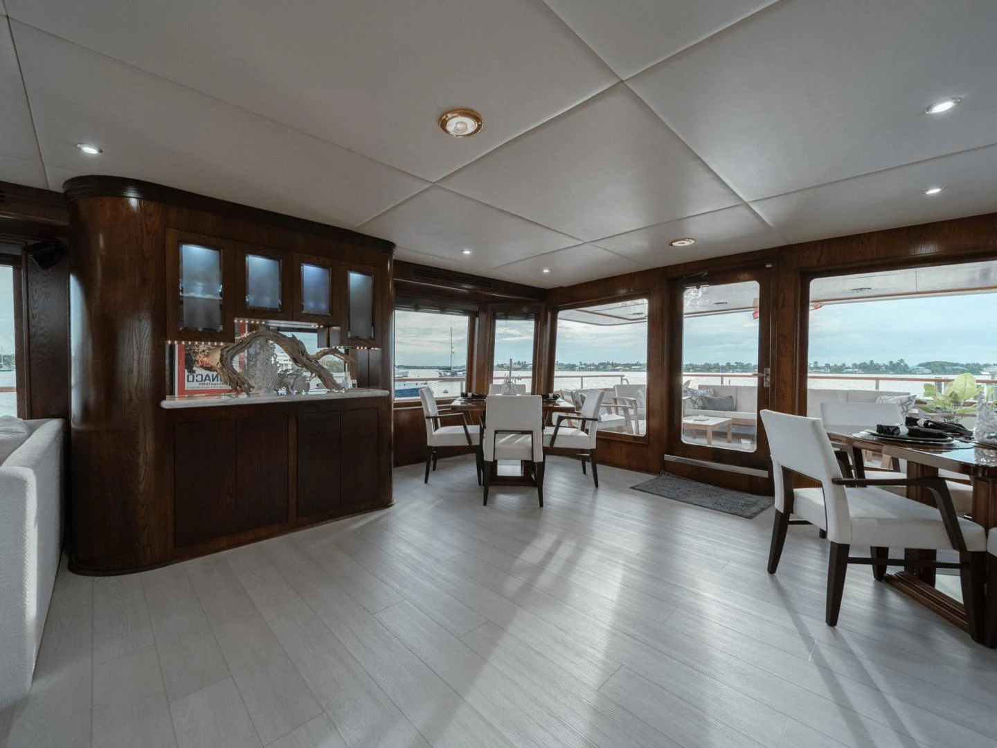 a room with a wood cabinet and chairs and a large window aboard SUP Yacht for Sale