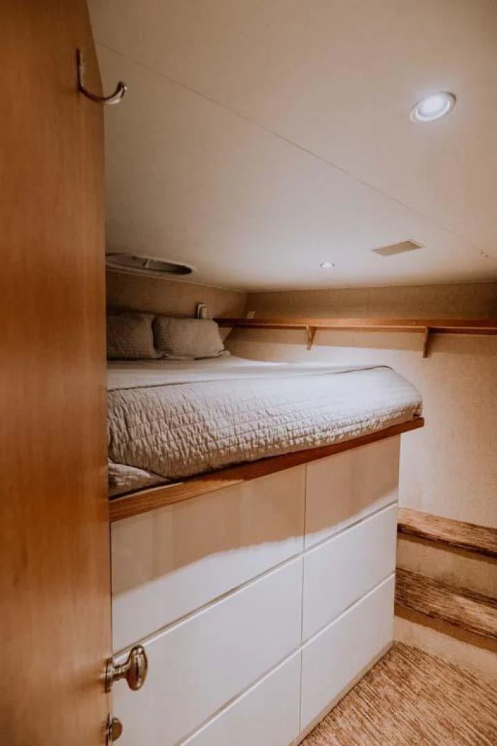 a bed with white drawers aboard SUP Yacht for Sale