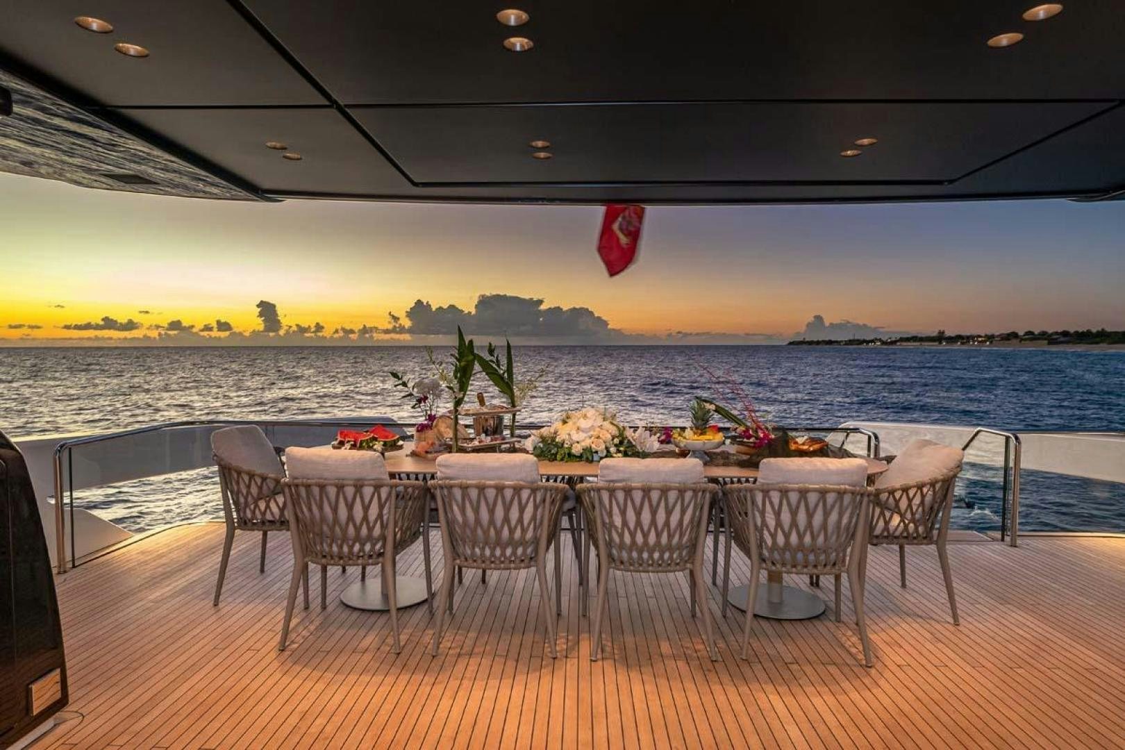 a table set for a meal on a deck overlooking a body of water aboard ANOTHER ONE Yacht for Sale