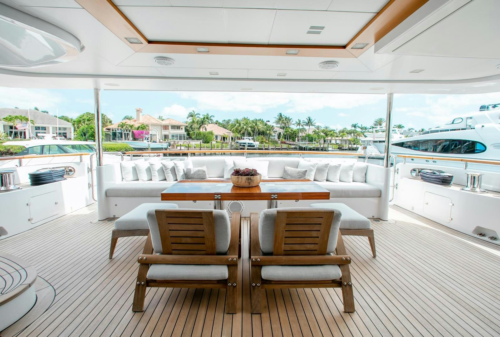 a dining table and chairs in a room with a view of the water aboard ALLORA Yacht for Sale
