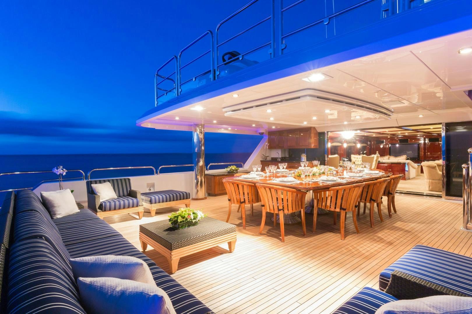 a large room with a table and chairs and a large pool aboard CASINO ROYALE Yacht for Sale