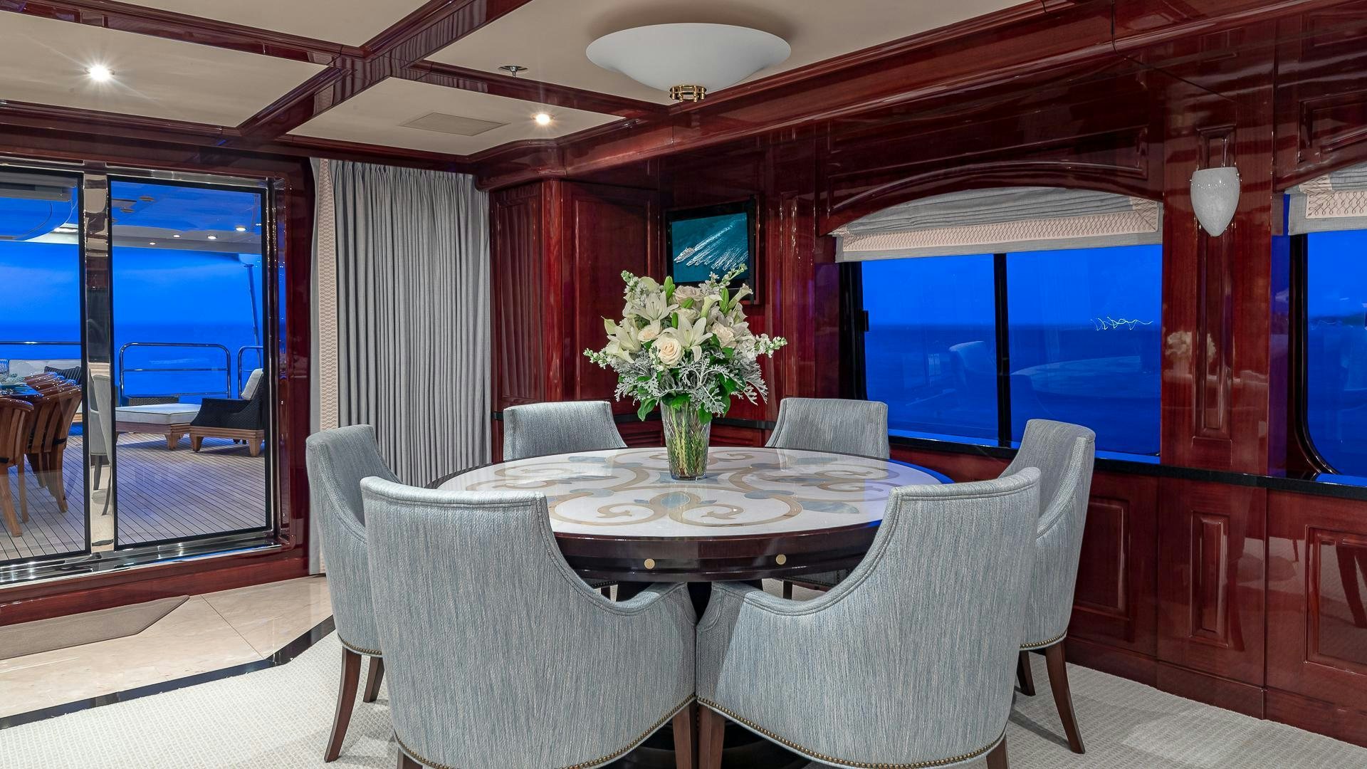 a dining table with chairs and a view of the ocean aboard CASINO ROYALE Yacht for Sale