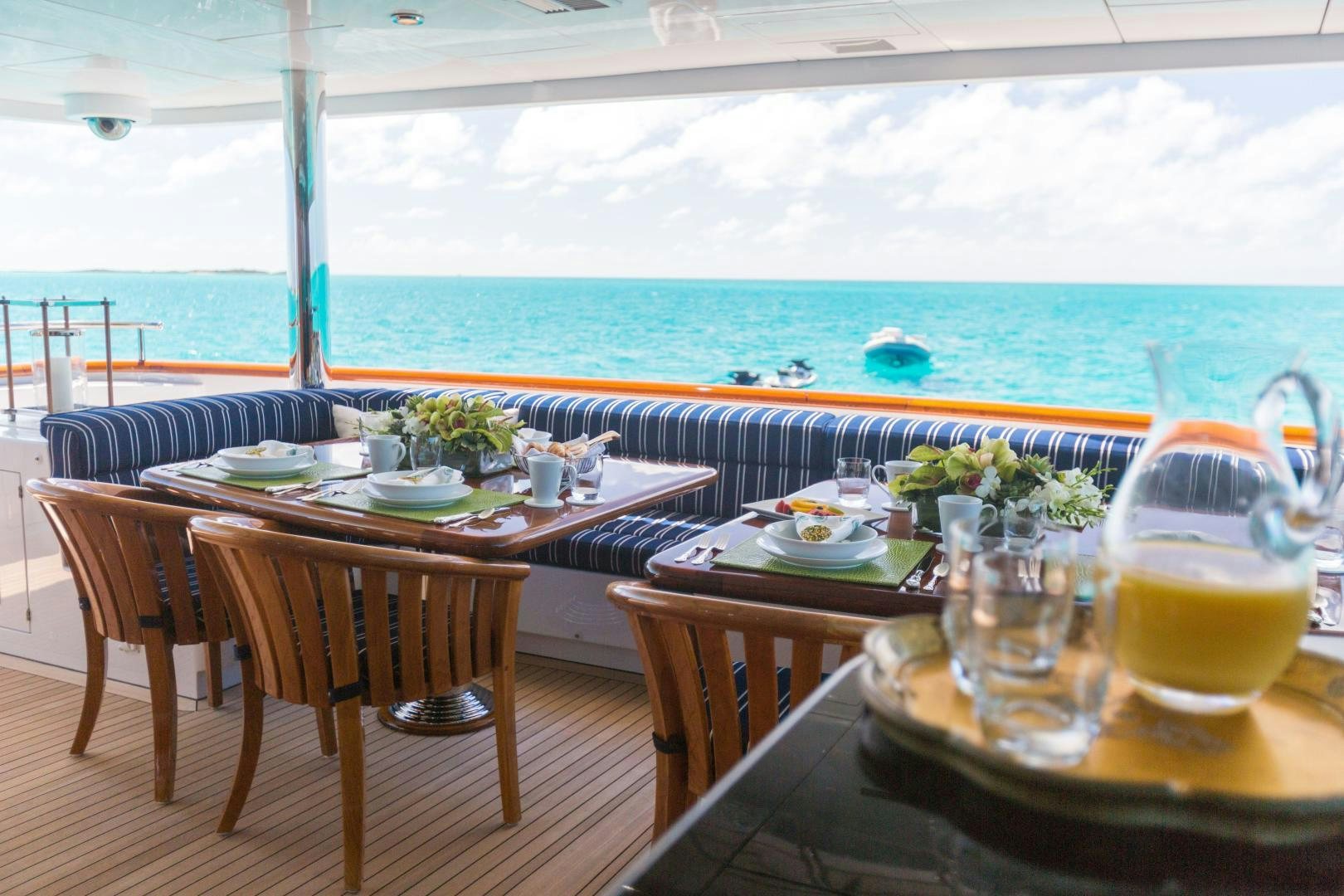 a table set for a meal on a balcony overlooking the ocean aboard CASINO ROYALE Yacht for Sale
