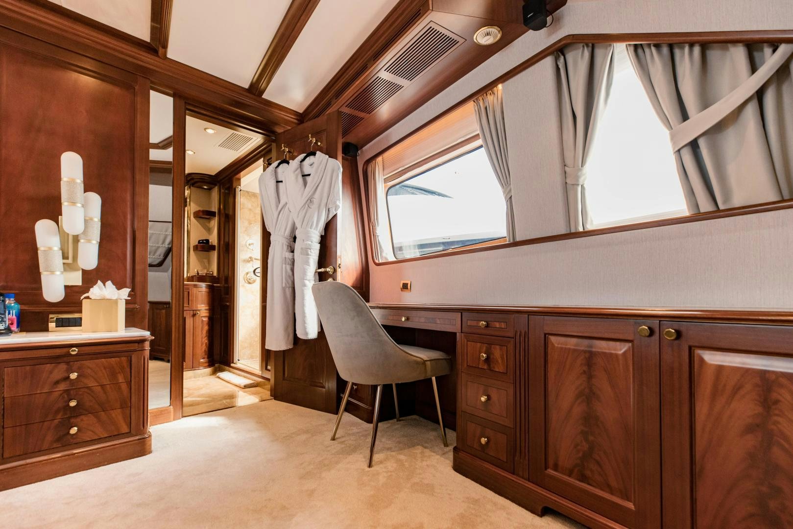 a room with wooden cabinets and a chair and a window aboard MAMMA MIA Yacht for Sale