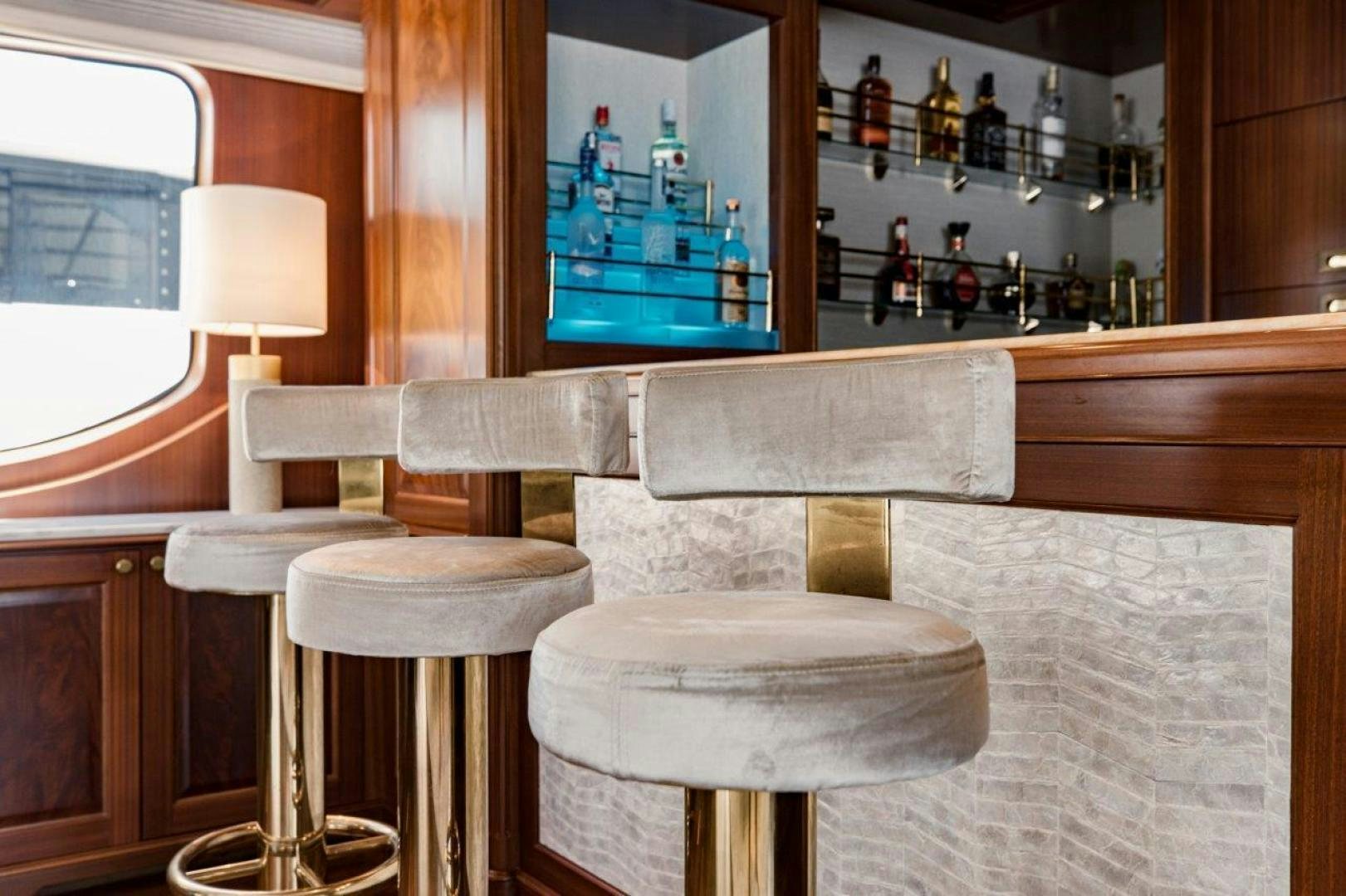 a room with a table and stools and a mirror aboard MAMMA MIA Yacht for Sale