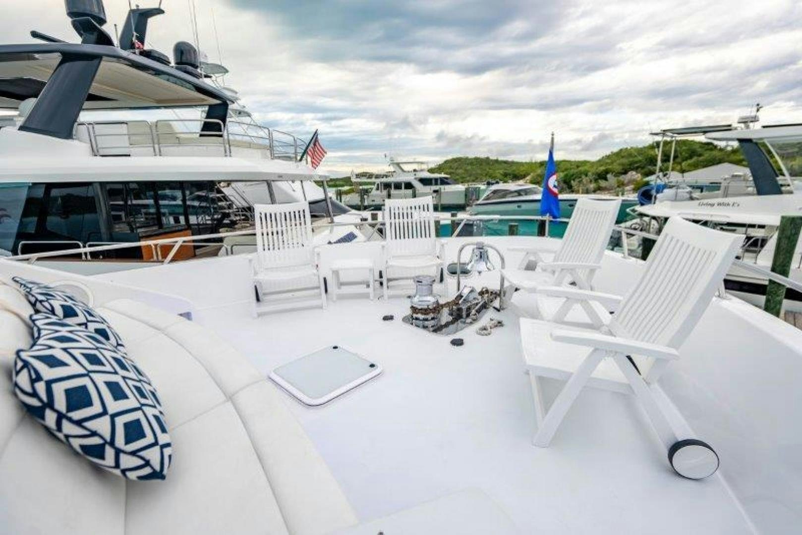 a deck with chairs and a table with a boat on it aboard TIE BREAKER Yacht for Sale