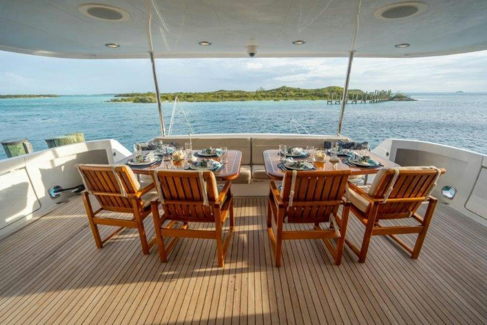 a group of tables and chairs on a deck overlooking a body of water aboard TIE BREAKER Yacht for Sale