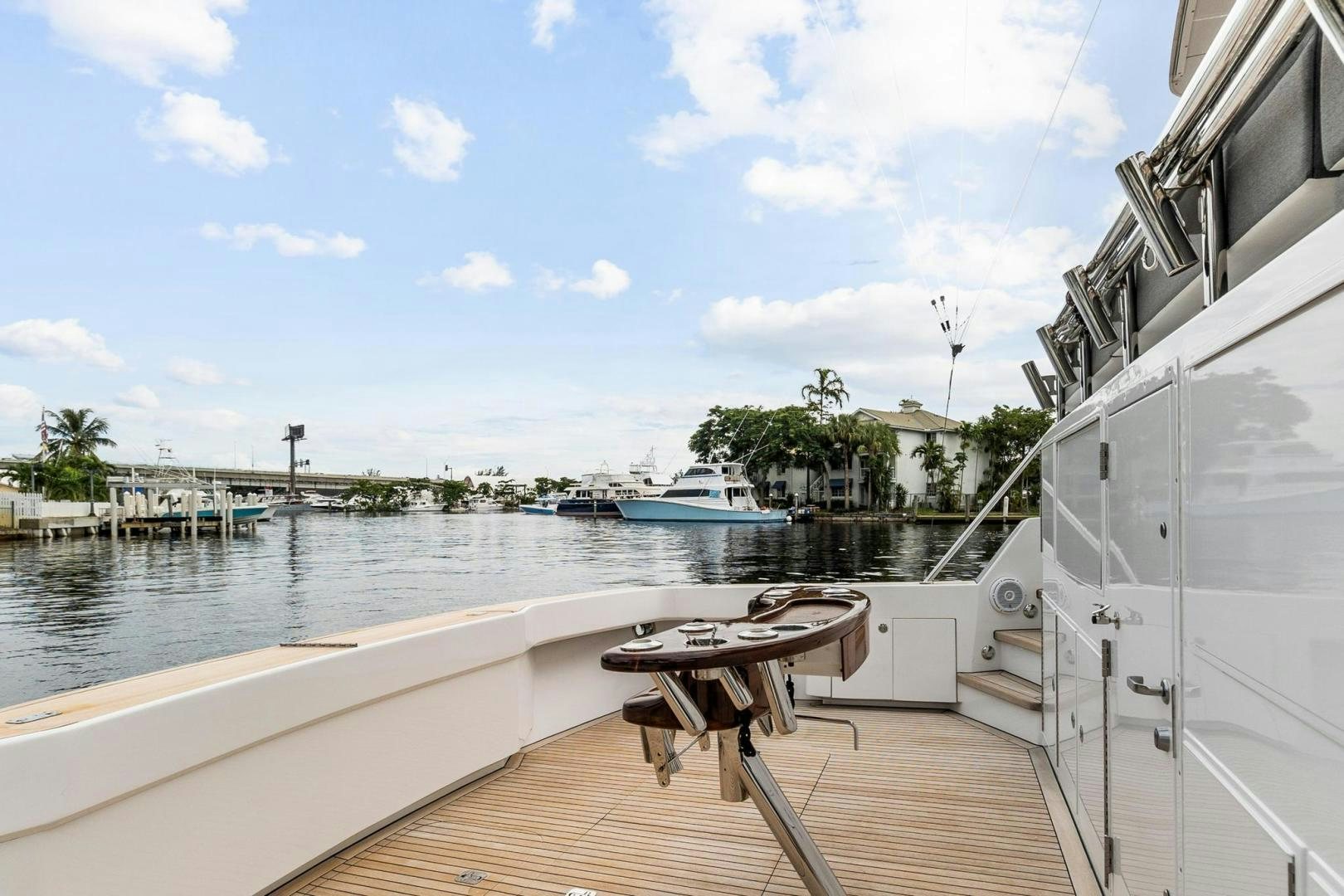 a deck with a table and chairs on it by a body of water aboard BELLISSIMA Yacht for Sale