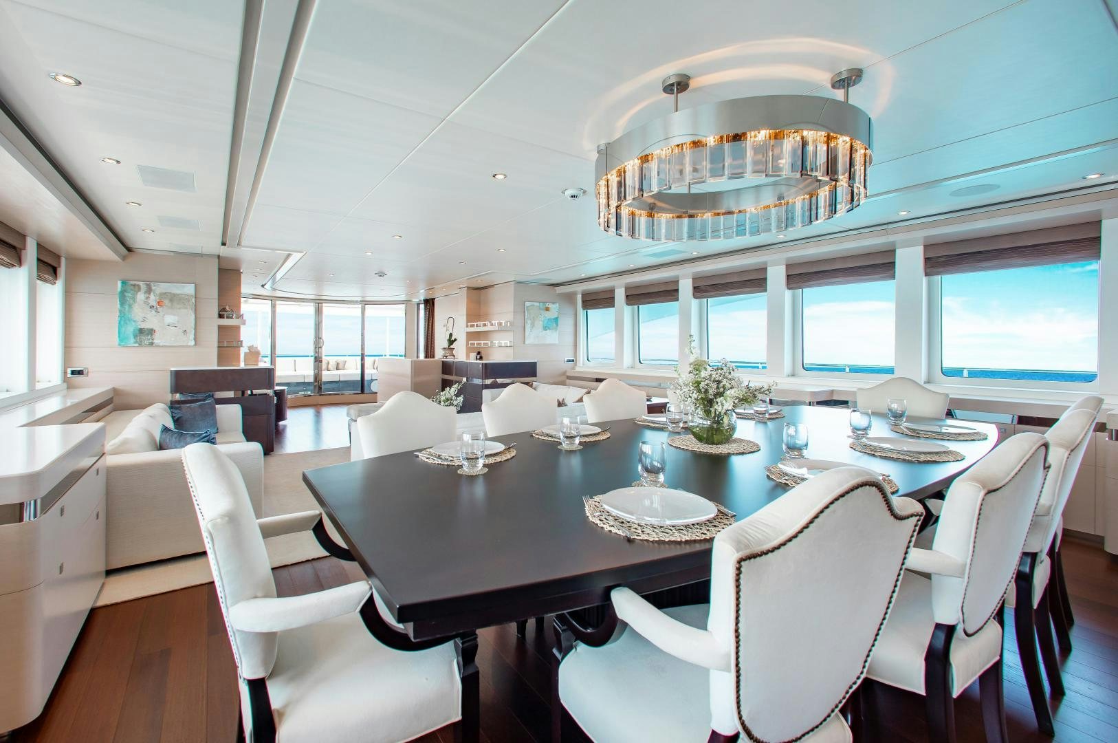 a large dining room with white chairs aboard LADY L Yacht for Charter