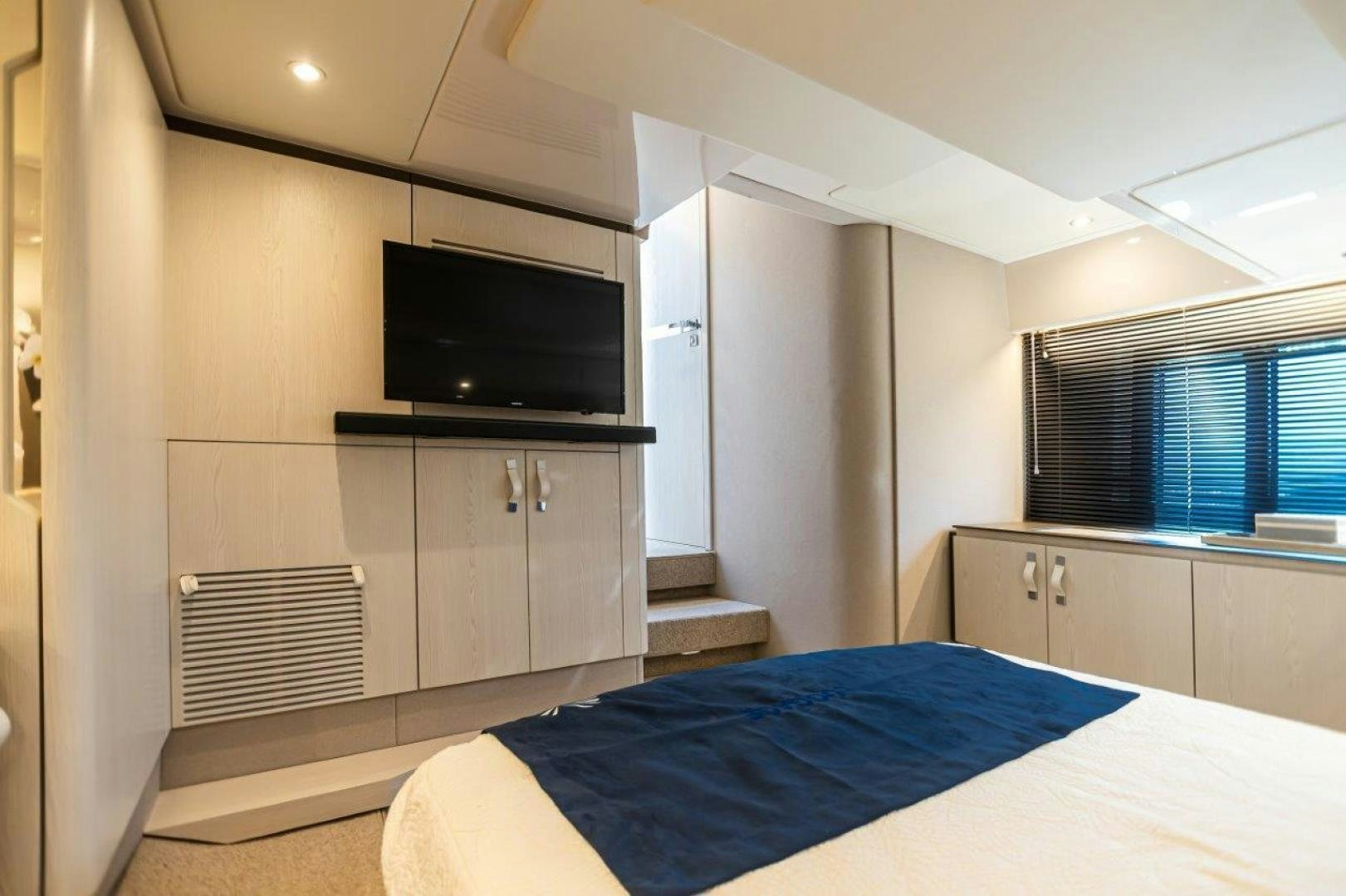 a bedroom with a tv and a bed aboard BLESSED Yacht for Sale