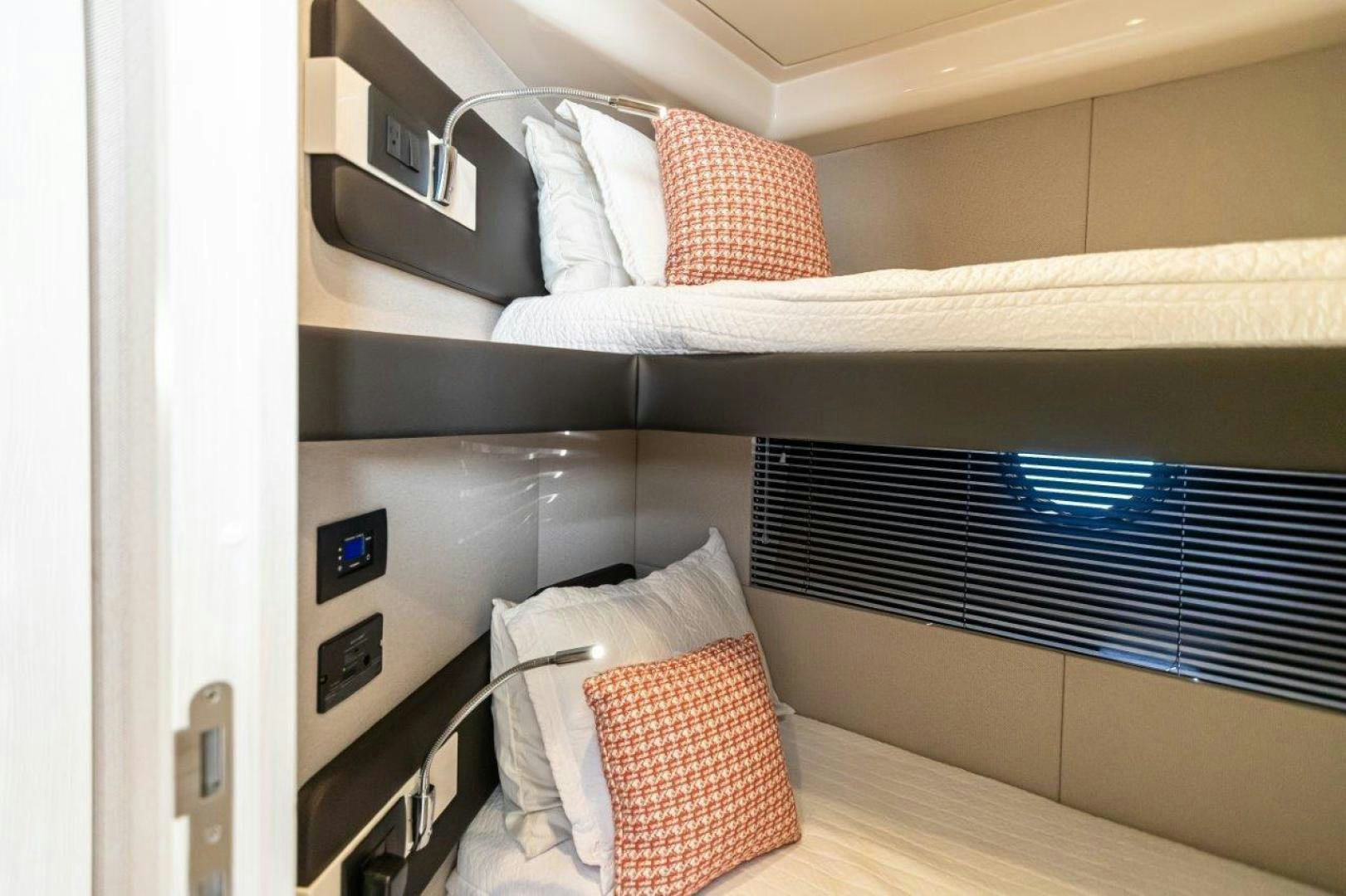 a bed with pillows and a window aboard BLESSED Yacht for Sale