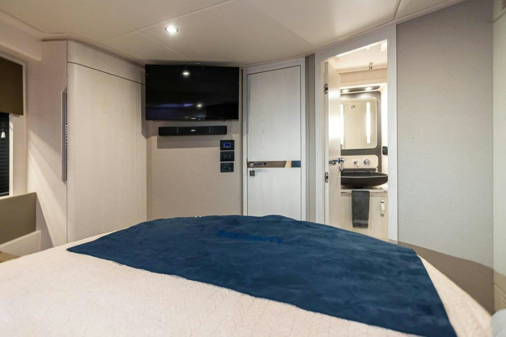 a bedroom with a blue bed sheet aboard BLESSED Yacht for Sale