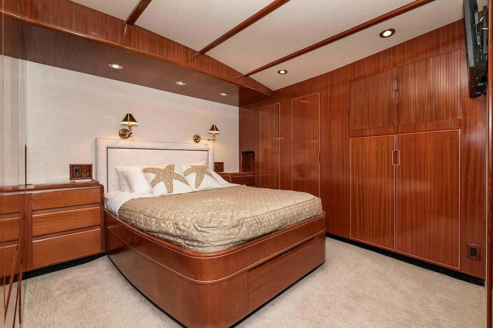 a bedroom with wooden furniture aboard ADVENTURER Yacht for Sale