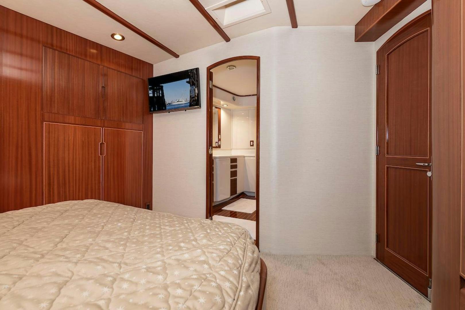 a bedroom with a bed and a television aboard ADVENTURER Yacht for Sale