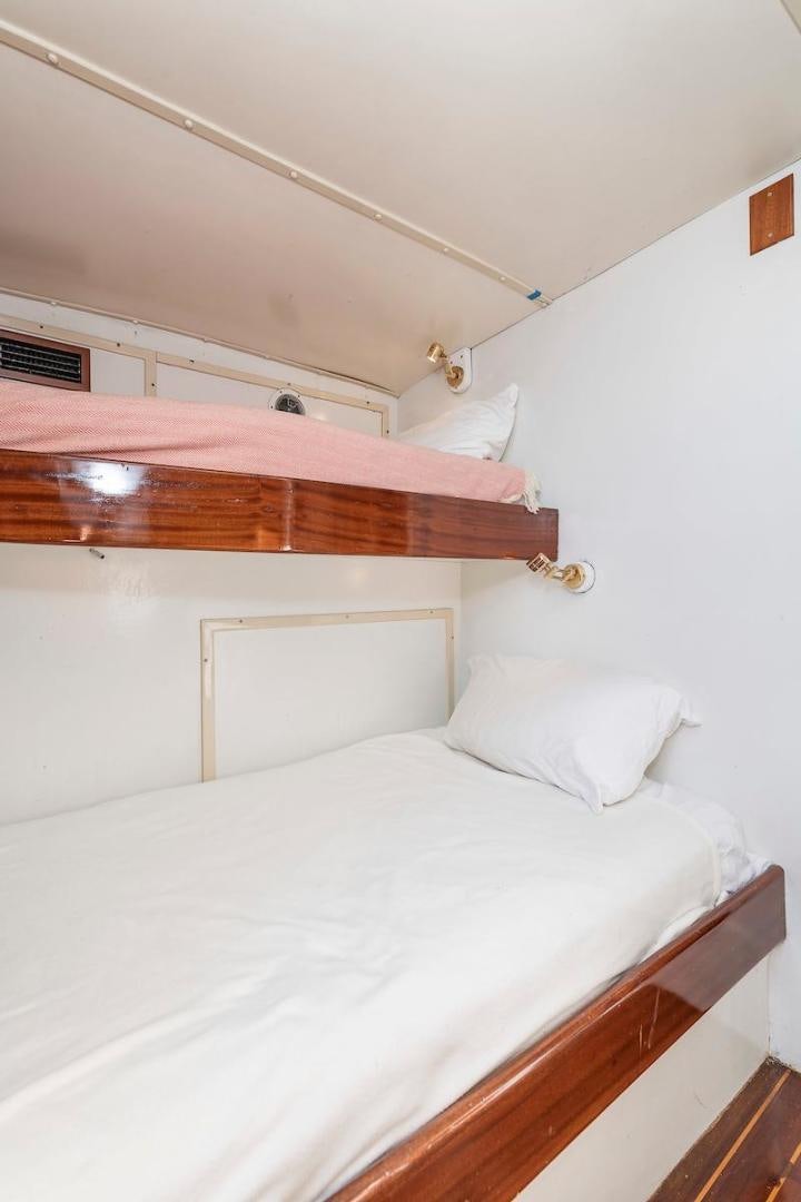 a bed with white sheets aboard ADVENTURER Yacht for Sale
