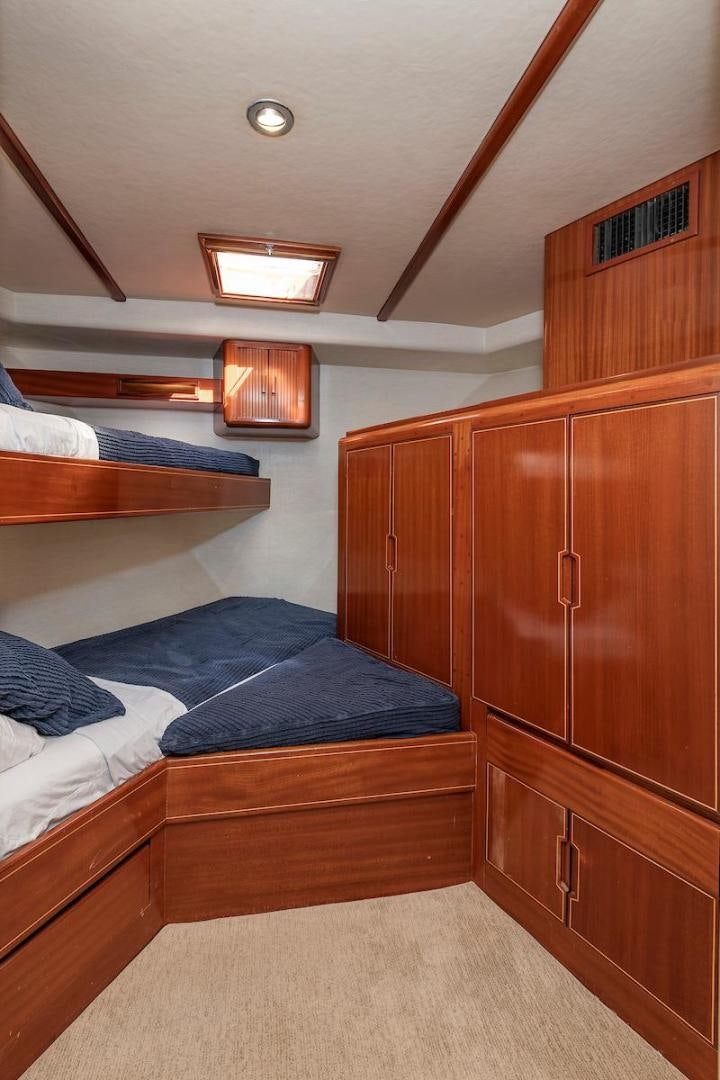 a bedroom with wooden furniture aboard ADVENTURER Yacht for Sale