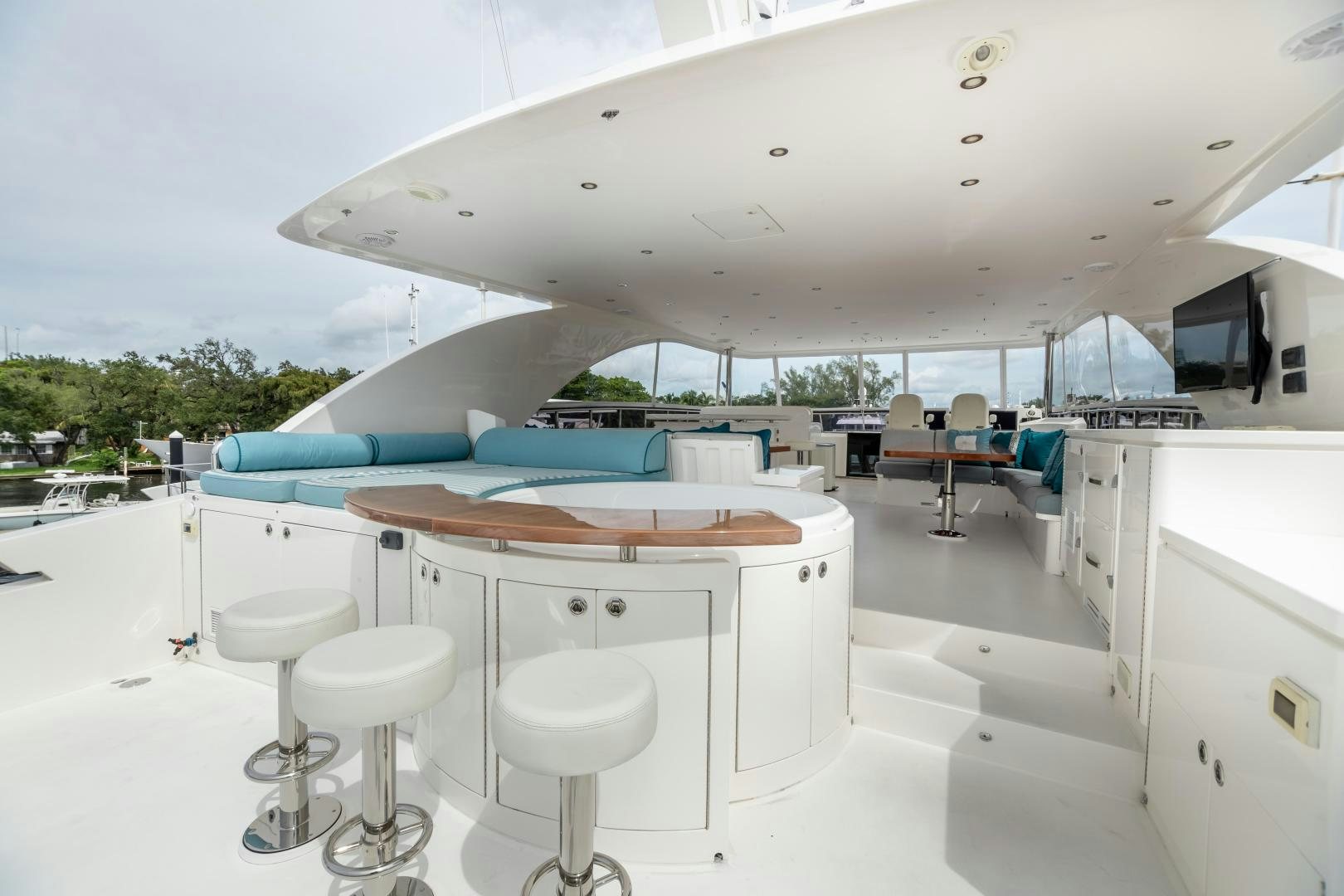 a room with a table and stools and a large white building aboard CUTTING EDGE Yacht for Sale