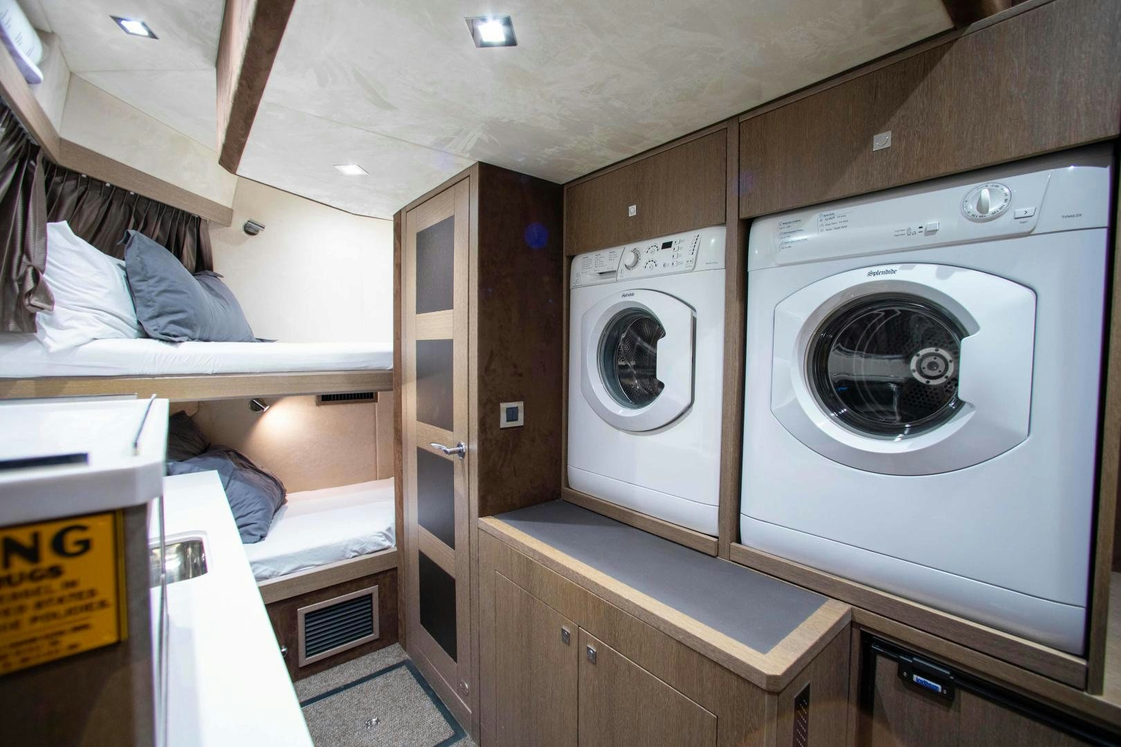 a room with a washing machine and a bed aboard LYLA BEE Yacht for Sale