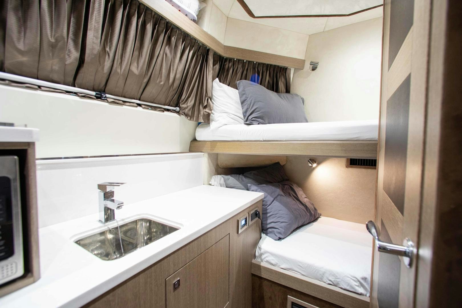 a small bedroom with a bed and a sink aboard LYLA BEE Yacht for Sale